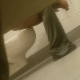 A voyeur cameraman records an unsuspecting girl using a toilet in an adjoining public restroom stall. He luckily captures the perfect side view showing the turd dropping out of her ass with soft plop sounds. About a minute.